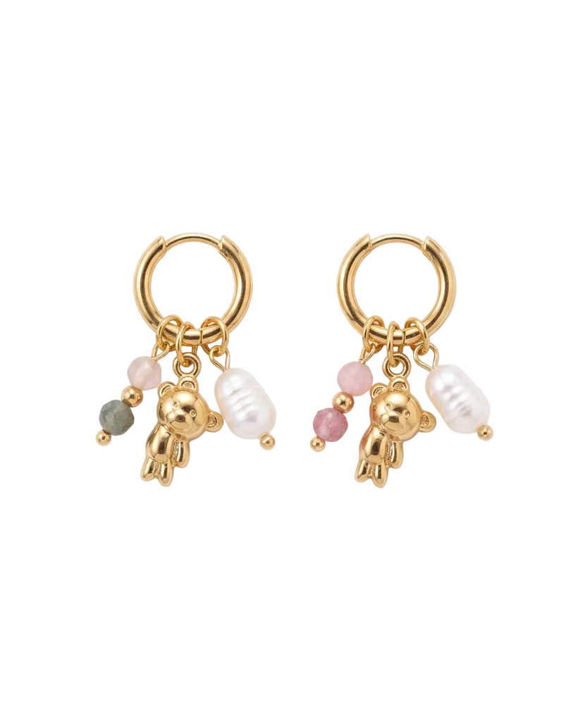 A pair of gold hoop earrings with dangling charms, including small gold teddy bear charms, white pearl beads, pink beads, and a single green bead, displayed on a clean white background.
